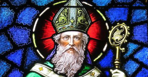 A stained glass window showing Saint Patrick with a long white beard